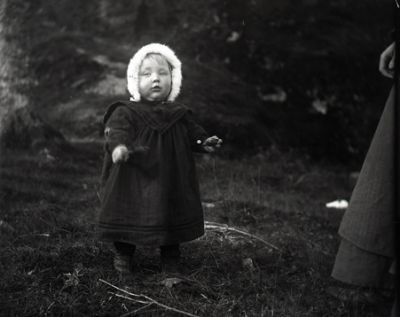 Liten flicka stående på gräsmatta
