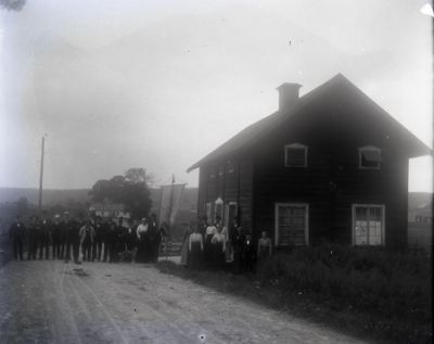 Stor grupp människor på väg intill byggnad
Nyckelord: Banderoll