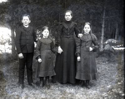 Kvinna två flickor och en pojke stående i skogen
Nyckelord: Dräkt