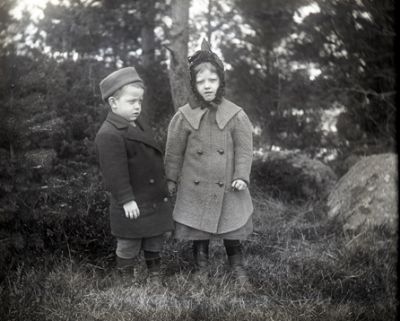 Pojke och flicka stående i skogen
Nyckelord: Dräkt