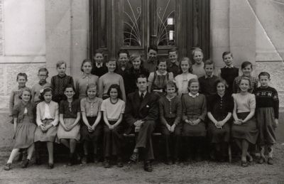 Skolklass med lärare fotograferade framför skolbyggnad
Nyckelord: Skolbyggnad Skolfoto Skolfotografi Klassfoto Klassfotografi 