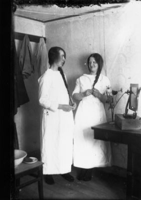 2 kvinnor stående i rum.
Nyckelord: Dräkt