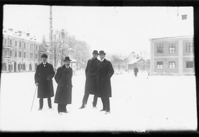 4 män stående på torg.
Nyckelord: Vinter