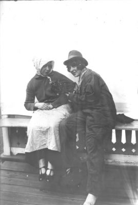 2 kvinnor sittande på veranda.
Nyckelord: Dräkt