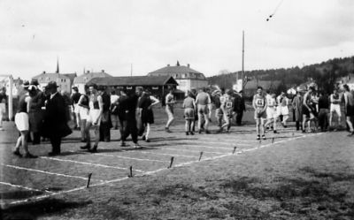 Ett antal personer på idrottsplats.
Nyckelord: Idrottsplats Folksamling