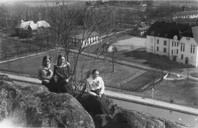 3 kvinnor sittande på berg med byggnader i bakgrunden.
Nyckelord: Utsikt