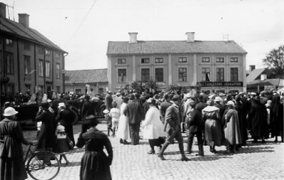 Ett antal personer som rör sig på torg.
Nyckelord: Folksamling Cykel