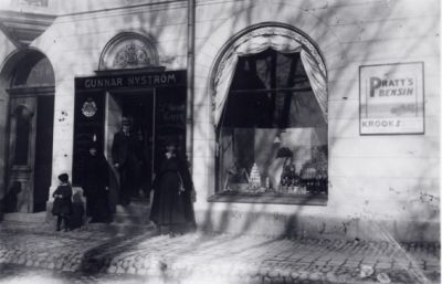 Ett antal personer vid affärsentré.
Nyckelord: Skyltfönster