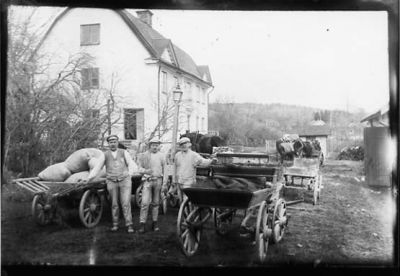 3 män stående vid vagnar.
Nyckelord: Häst Vagn