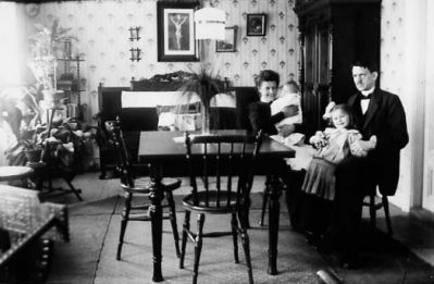 Familj sittande vid bord.
