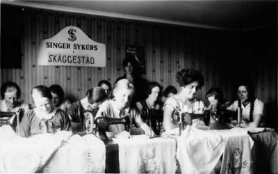 Ett antal kvinnor vid symaskiner.
