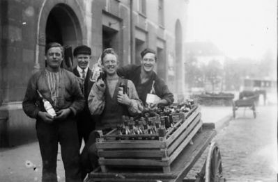 4 män stående vid kärra.
Nyckelord: Kärra Flaska