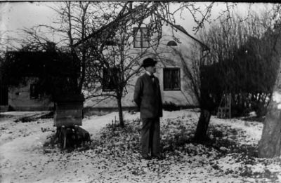 Man stående framför byggnad.
