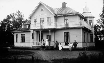 Ett antal personer framför byggnad.
Nyckelord: Hund