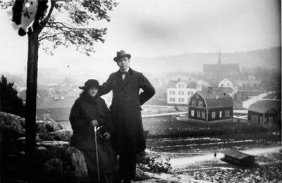 Man och kvinna på kulle med bebyggelse i bakgrunden.
