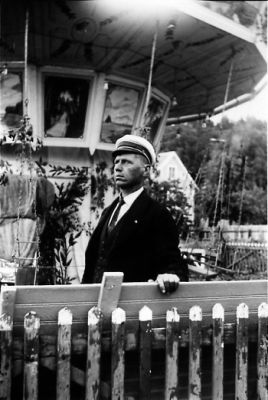 Man stående framför karusell.
