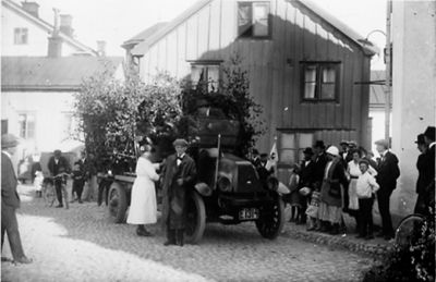 Ett antal personer stående och gående runt en lövad lastbil.
Nyckelord: Lastbil