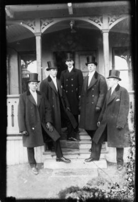 5 män stående på trappa till byggnad.
Nyckelord: Dräkt