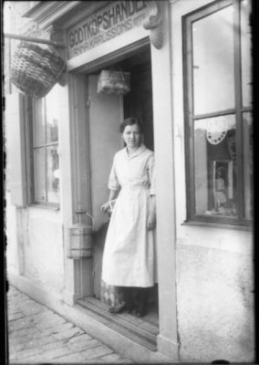 Kvinna stående i dörröppning.
