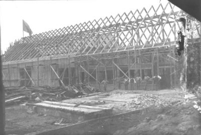 Ett antal män stående vid ett husbygge.
Nyckelord: Byggnadsställning Flagga