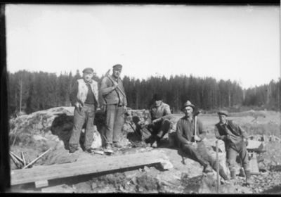 2 stående och 3 sittande män på beredskapsarbete.
Nyckelord: Verktyg