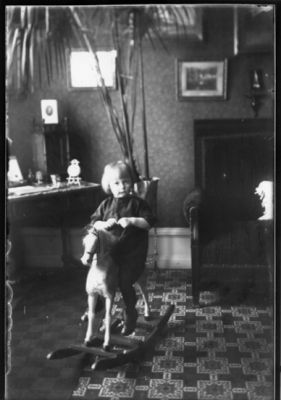 Barn sittande på gunghäst.
