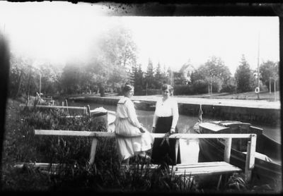 2 kvinnor på brygga vid vattendrag.
Nyckelord: Brygga