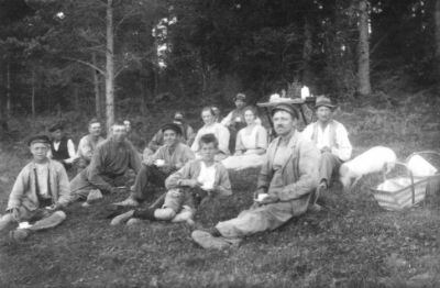 Ett antal personer sittande i skogsbacke.
Nyckelord: Skogsbacke Picnic