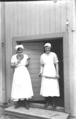 2 kvinnor stående i dörröppning.
Nyckelord: Hålkaka Brödkavel Dräkt