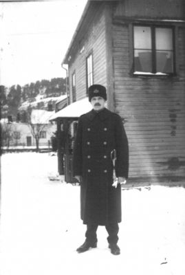 Man i uniform stående framför byggnad.
Nyckelord: Vinter Värja Sabel