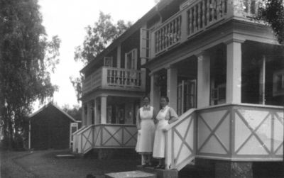 2 kvinnor stående på tappa till byggnad.
Nyckelord: Veranda Balkong