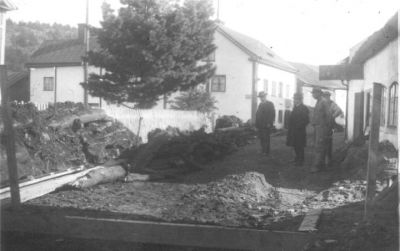 4 män stående på uppgrävd gata.
