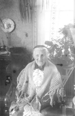 Kvinna sittande i stol.
