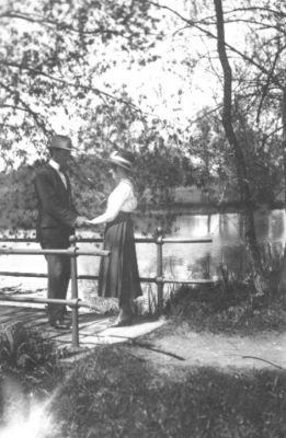 Man och kvinna stående på bro vid vattendrag.
Nyckelord: Bro