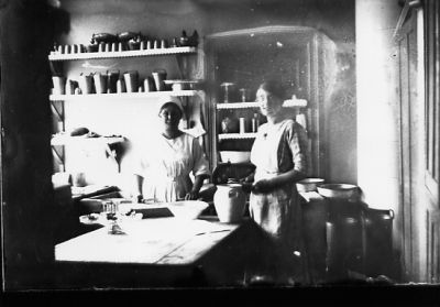 2 kvinnor stående bakom bord i kök.
Nyckelord: Kök Krus