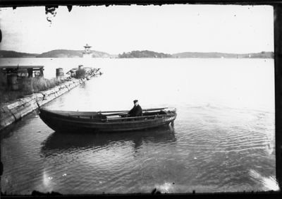 Man sittande i roddbåt.
