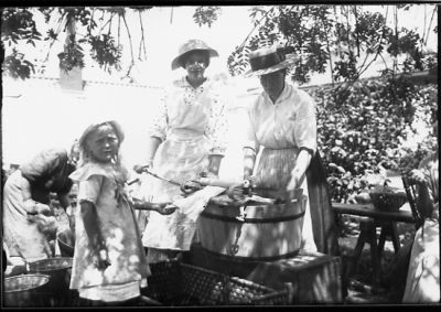 2 kvinnor och 1 flicka stående vid tvättkar.
Nyckelord: Tvättkar