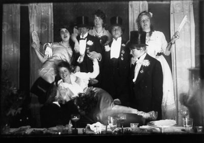 8 utklädda personer stående eller sittande vid ett bord.
Nyckelord: Fest Maskerad