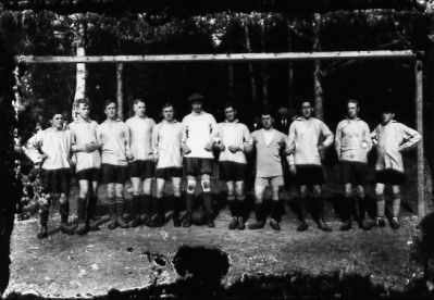 11 män i fotbollskläder stående framför målställning.
Nyckelord: Målställning