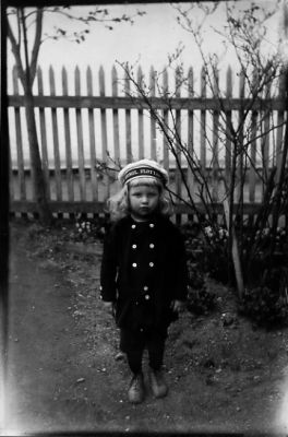 Flicka stående framför staket.
Nyckelord: Staket