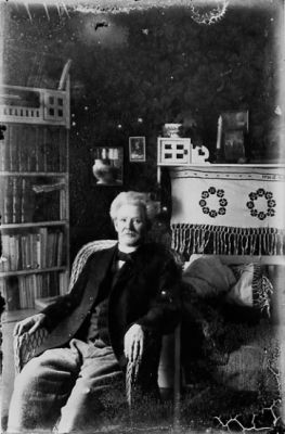 Man sittande i korgstol i rum.
Nyckelord: Korgstol Bokhylla