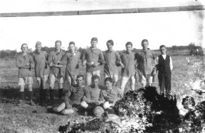 9 stående och 3 sittande män på gräsmatta.
Nyckelord: Fotbollslag
