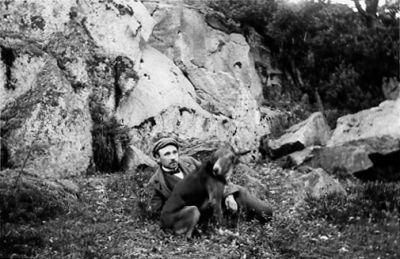 Man och hund sittande framför berg.
Nyckelord: Hund Berg