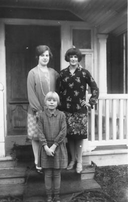 2 kvinnor och 1 flicka stående på veranda.
Nyckelord: Veranda Bostad