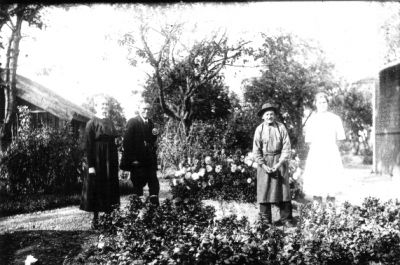 2 män och 2 kvinnor stående i trädgård.
Nyckelord: Blommor