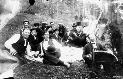 14 män sittande vid picnic-filt. En med dragspel i knät.
Nyckelord: Dragspel Kärra Picnic