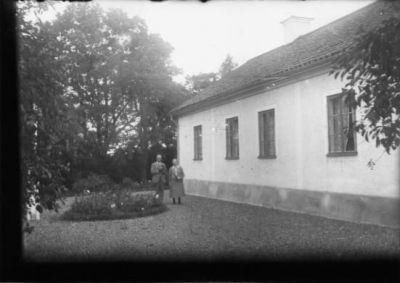 Man och kvinna stående intill byggnad.
