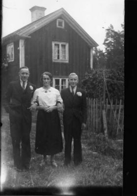 2 män och 1 kvinna stående framför byggnad.
Nyckelord: Staket