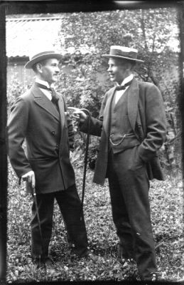 2 män stående i gräset.
Nyckelord: Käpp Trädgård