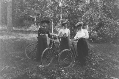 3 kvinnor stående med cyklar i naturen
Nyckelord: Cykel Hatt Dräkt